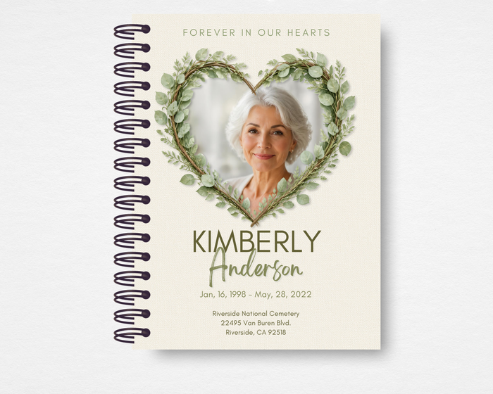 Botanical Heart Memorial Guest Book spiral-bound cover mockup showing eucalyptus heart wreath design with photo placeholder, name, dates, and location fields on cream background