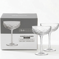 Labeled graphic showing a set of two diamond-cut coupe glasses with product features and branding (details in description).
