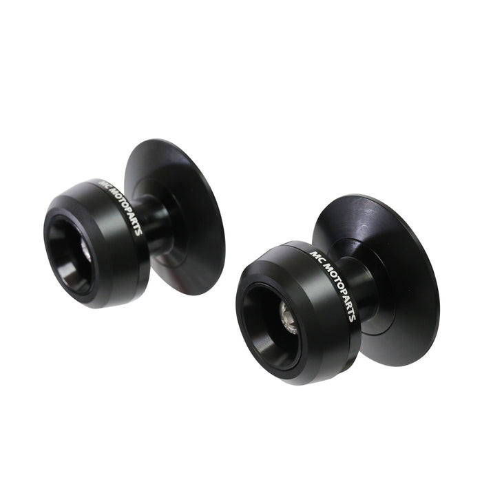 Black MC Motoparts swingarm spools for Aprilia Dorsoduro 750, 900, 1200 models, featuring 6mm mounting hardware.