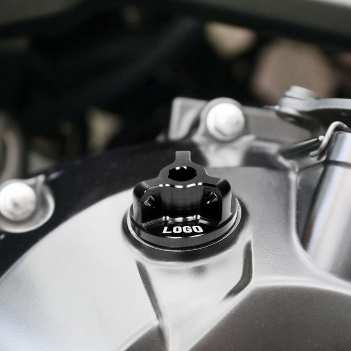 Black engraved Honda CB300R oil filler cap by MC Motoparts with logo, shown installed on motorcycle engine.