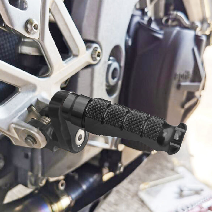 Black 25mm extension foot pegs for BMW S1000R, S1000RR, R1200GS, by MC Motoparts, installed on motorcycle front view.