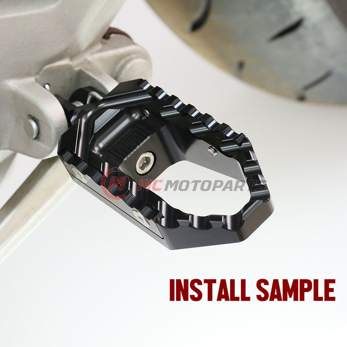 Front view of MC Motoparts touring wide foot pegs installed on Yamaha XJR1300 and XJ6 Diversion motorcycle, black finish.