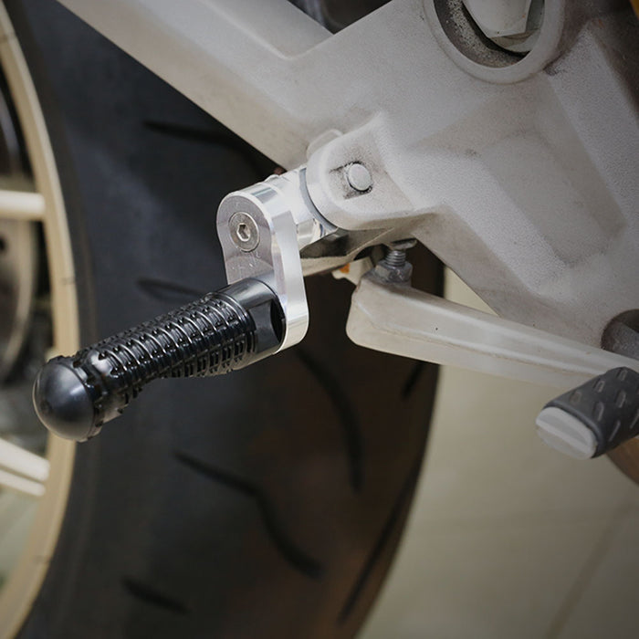 Black MC Motoparts 25mm adjustable front foot pegs for Yamaha YZF R1, R3, R6, R25, and R125 motorcycles, installed on bike.