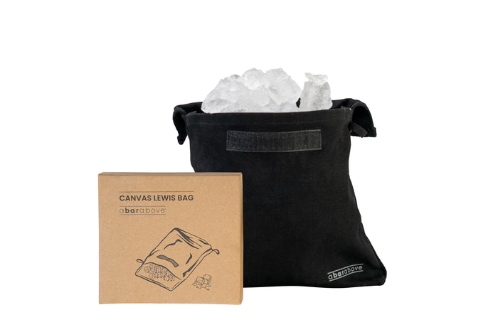 Black canvas Lewis bag filled with crushed ice, displayed next to its brown cardboard packaging.