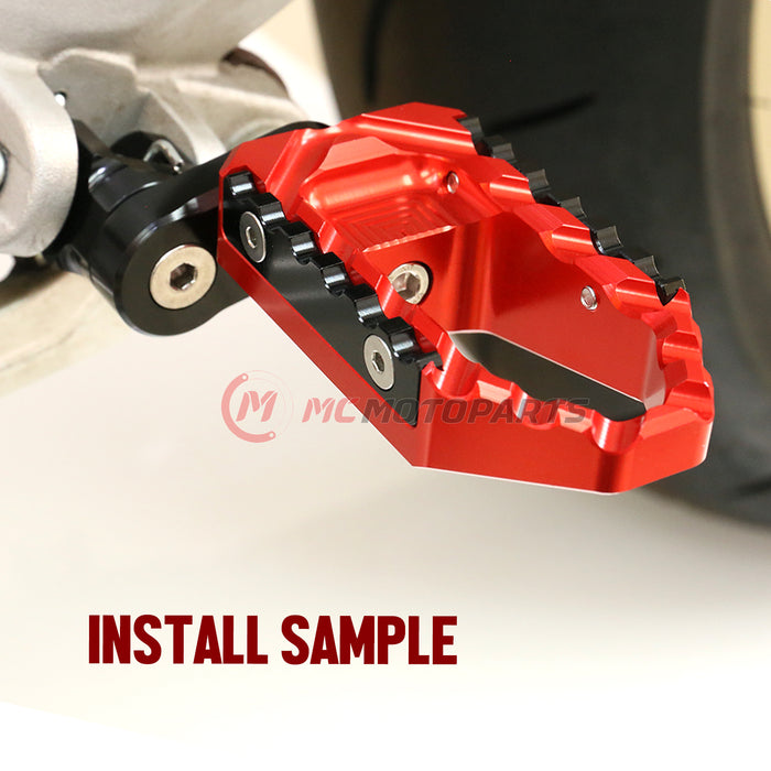 Rear 25mm extension touring wide foot pegs for Aprilia Tuono V4R by MC Motoparts, showcasing black extended foot pegs for rider comfort.