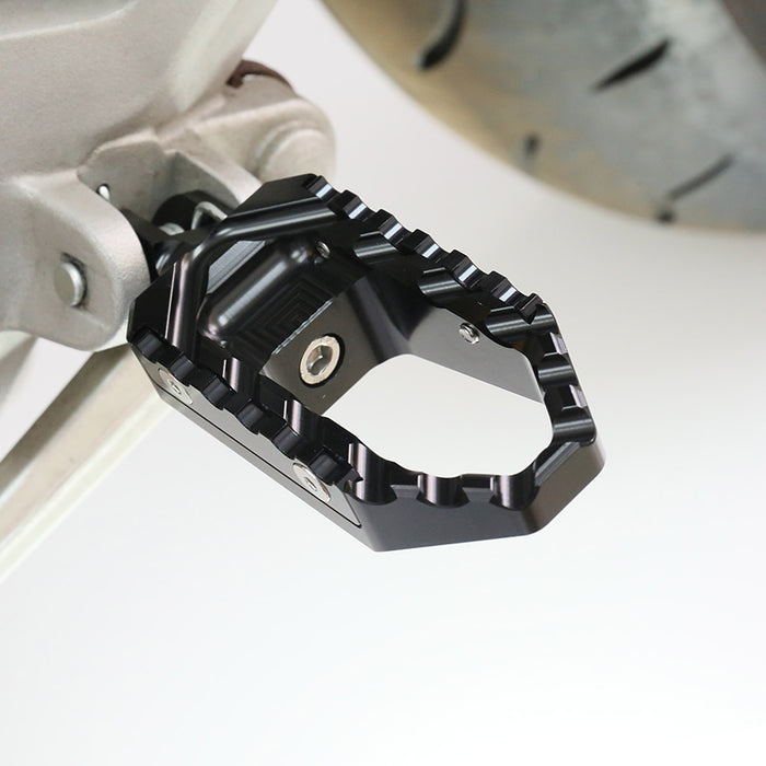 Rear MC Motoparts touring wide foot pegs for Honda CBR1000RR and CBR600RR motorcycle, black finish, installed on bike.